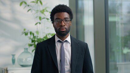 Portrait in office serious African American business man pensive thinking gazing looking at camera confident ethnic male businessman guy worker company CEO entrepreneur posing at workplace headshot
