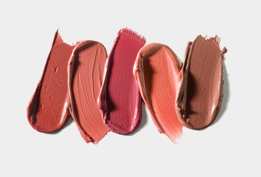 Set of colorful lipstick or cream makeup swatches on light background. Beauty product sample swatch concept for cosmetic advertising and design.