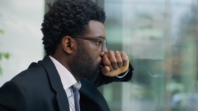 Suffering African American man business guy male businessman stressed overworked panic attack leaning glass of window in office problem bankruptcy dismissal unemployment trouble stress work failure