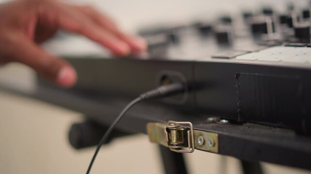 Technician connects equipment, Musician arranging sound equipment outdoors before performance, Performer finetunes sound setup outdoors using portable equipment before their street concert
