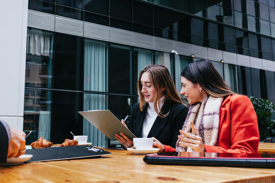 Young Hispanic women teamwork working in the business sector and using laptop outdoors in Public park in businesswoman empowerment concept in urban scene in winter