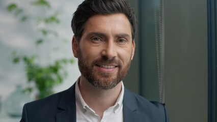 Portrait close up Caucasian middle-aged business man look window in office looking at camera smiling adult businessman male professional specialist manager company CEO smile positive job work carefree