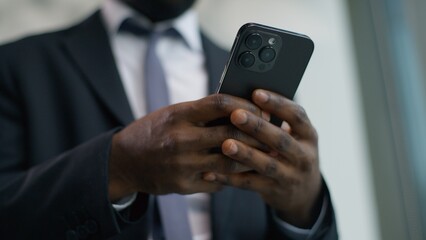 Upset African American male guy businessman business man in office looking smartphone reading bad news worried with mobile phone frustrated stressed disappointed sad financial failure digital error