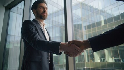 Caucasian businessman smiling business man shaking hands with African male partner in modern office handshake greeting cooperation success teamwork deal partnership agreement multicultural meeting