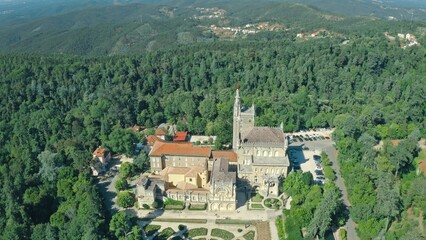 Top view of beautiful building Bussaco Palace in Luso Portugal surrounded green park trees forest mountains garden portuguese architecture cultural heritage travel in Europe traveling tourism trip