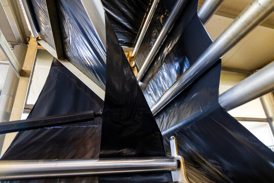 Industrial machine producing black plastic sheeting for trash bags