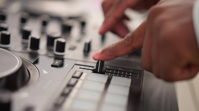 closeup dj hands on mixer adjusting faders and knobs, intimate studio lighting highlights fingertip technique, precision control of channels and pads for electronic music production, tactile focus