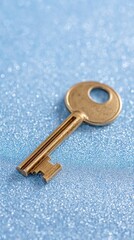 Golden key on glittering blue surface