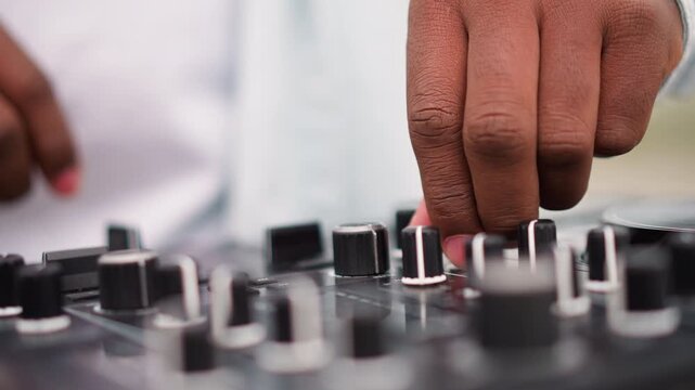 dj hands on mixer closeup urban outdoor practice session, fingers adjusting knobs and faders with precise technique, tactile focus, soft natural light, detailed gear, concentrated musician shaping