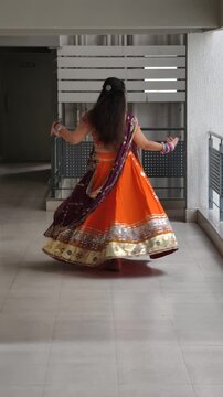 Indian woman performing Garba dance in vibrant chaniya choli with full flair, golden lace details, oxidized jewellery and flowing dupatta, celebrating Navratri, tradition, rhythm and festive culture.