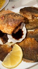 Fried fish with lemon and soy sauce. Lake fish called crucian carp.