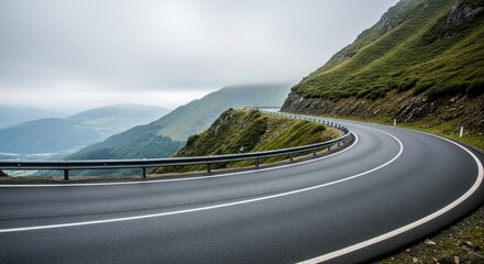 Winding mountain road with a view of rolling hills under a cloudy sky