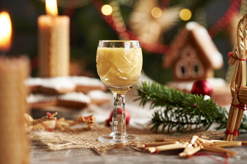 A glass of Eiercognac with candles and Christmas decoration