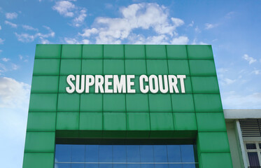 Modern green facade with a large SUPREME COURT sign against a cloudy blue sky.