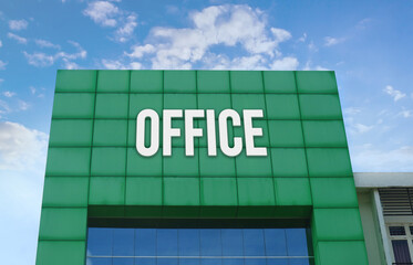 Modern green facade with a large OFFICE sign against a cloudy blue sky.