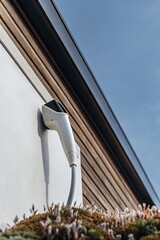 An electric vehicle charger mounted on a house wall