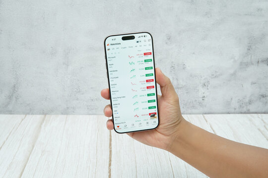 Rawang, Selangor, Malaysia - &lrm;January 21, 2026 - Hand holding smartphone displaying moomoo stock trading application interface on screen.
