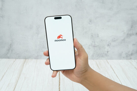 Rawang, Selangor, Malaysia - &lrm;January 21, 2026 - Hand holding smartphone displaying moomoo stock trading application interface on screen.