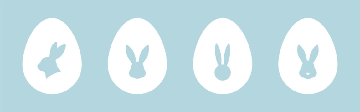 Set of four white Easter egg silhouettes with rabbit cutouts on light blue background. Vector illustration of bunny shapes inside eggs.