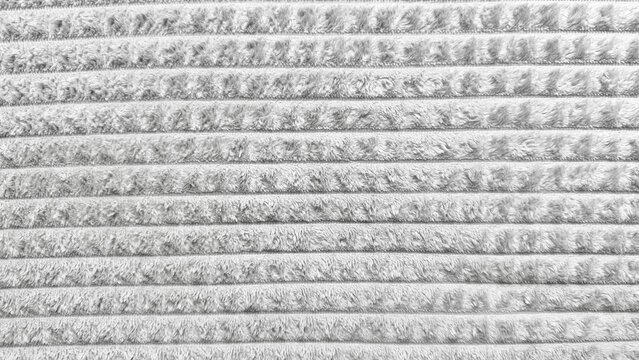soft gray corduroy texture closeup plush striped fabric abstract background fuzzy rippled pattern evokes cozy winter warmth ideal for wallpaper or design banner