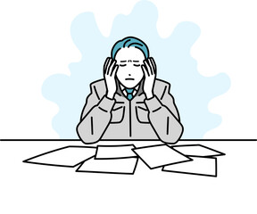 デスクで作業をしている作業着の男性のイラスト