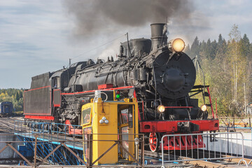 Steam retro locomotive turns around on the circle. 