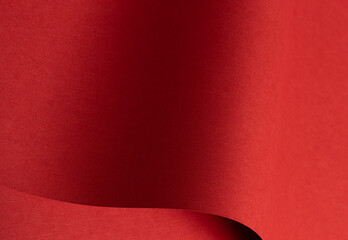 Red textured paper background with curved fold and soft depth. Matte surface with rough grain and