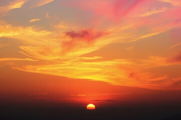 a sunset with clouds and a plane flying over it