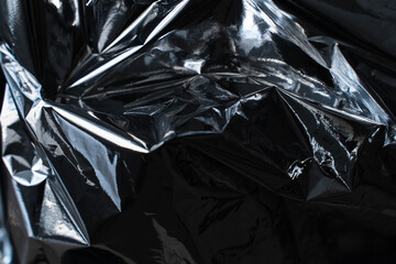 Dark metallic foil texture with deep folds and glossy reflections