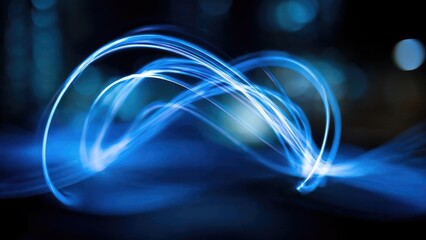 Abstract long-exposure of electric blue light trails looping and spiraling in the dark. Concept Abstract photography, Long exposure, Light trails, Electric blue, Night photography