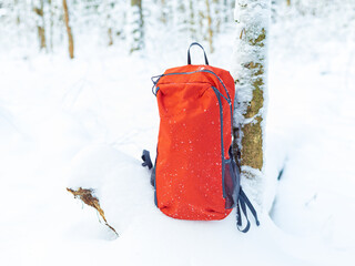A hiking backpack in the snow in a winter forest.