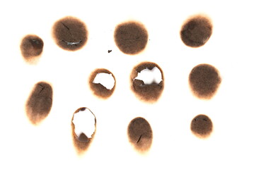 Collection of burnt holes in piece of paper isolated on white background, design elements