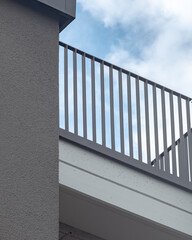 Balcony view with gray railing under cloudy sky at a modern building