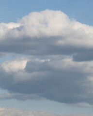 Clouds drift over a blue sky during the afternoon in an open landscape