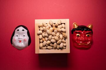 Oni and Okame masks with soybeans for seasonal celebration