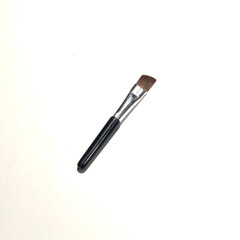 Mini brush for makeup close up on plain background. Beauty tools