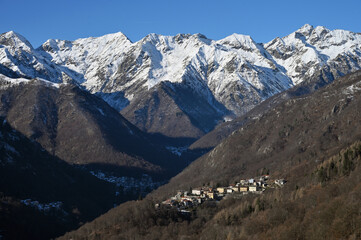 Fototapeta premium Snow-capped mountain peaks on a sunny clear winter day in Piedmont