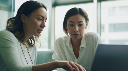 premium commercial stock photo of a senior mentor coaching a junior colleague while reviewing work on a laptop in office, supportive mentoring vibe, focused attentive expressions,