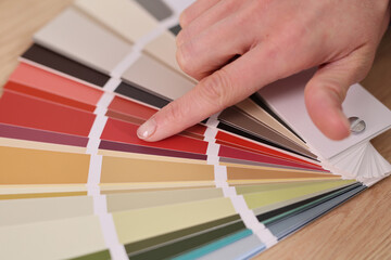 A hand delicately selects from a spectrum of color swatches, reflecting the process of inspiration...