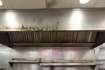 Exhaust hood shows dirt and grime in commercial kitchen over time during busy lunch service in restaurant