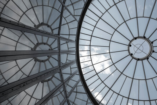 Modern glass dome ceiling architecture with pattern symmetry and circle skylight structure creating bright geometric interior perspective