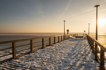 Wooden pier and frozen Baltic sea in Kuznica. Winter landscape on Hel Peninsula. Poland, Europe