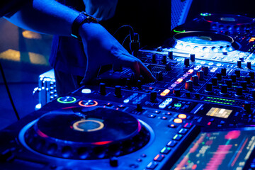 Obraz premium DJ mixing tracks on professional sound equipment at nightclub