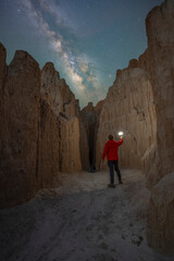 A man hiking through a moon cave under the starry night sky in Cathedral Gorge State Park Nevada 
