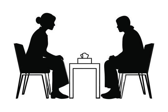 silhouette of two people sitting on chairs facing each other at a table with a tissue box