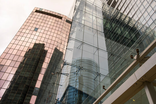 Modern architecture skyscraper with glass office facade and reflection in urban paris city skyline from low angle in bright sky for corporate business