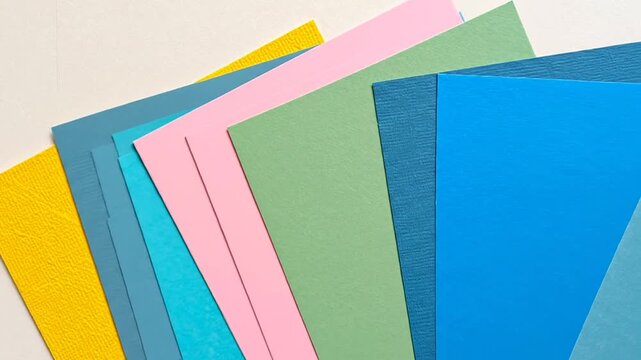 Assortment of colorful paper, in blue, pink, green, yellow, and blue, arranged in a fan shape