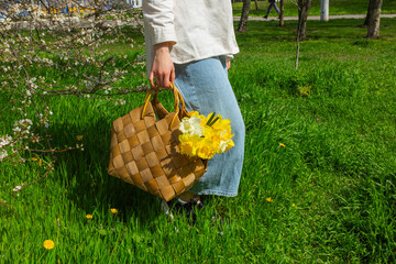 Young woman holding a basket filled with daffodils