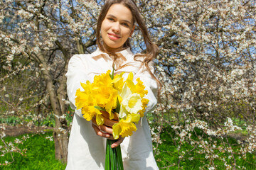 Young woman holding a bouquet of daffodils in her hands