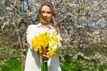 Young woman holding a bouquet of daffodils in her hands